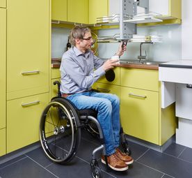 Person im Rollstuhl in barrierefreier Küche