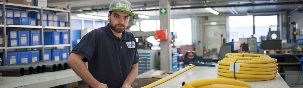 Mann hantiert mit gelben Schläuchen in der Halle der Firma Maertin, Freiburg