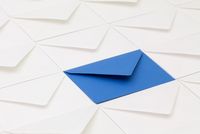 Blauer Briefumschlag umgeben von weißen Briefumschlägen