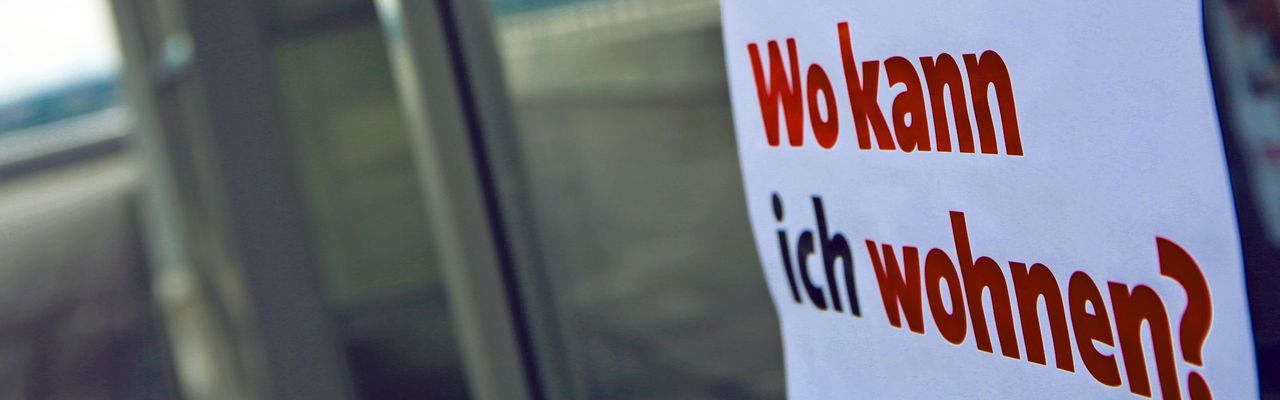 Schild mit der Aufschrift "Wo kann ich wohnen?" an Tür